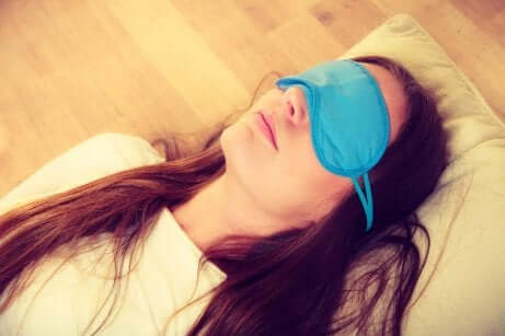 En kvinne som sover med sovemaske