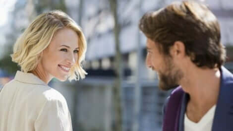 En mann og en kvinne som smiler til hverandre på gaten.