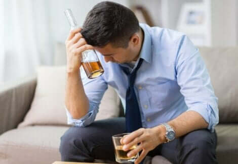 En mann som drikker alkohol og føler seg stresset.
