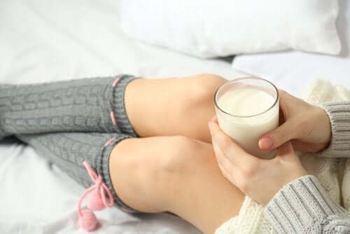 Den beste tiden å spise visse matvarer: Kvinne som holder et glass melk
