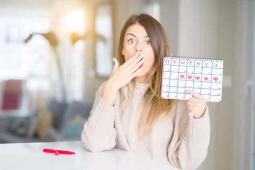 En kvinne som holder opp en kalender over menstruasjonssyklusen.