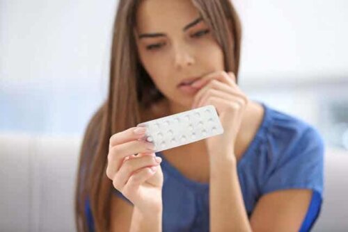 En kvinne som ser på p-piller.