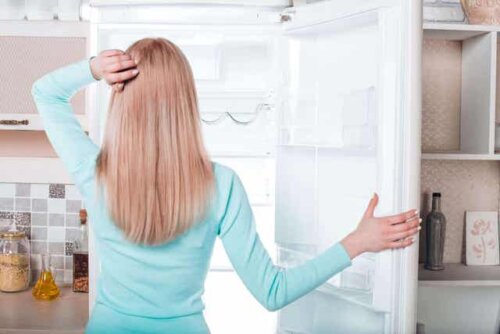 En kvinne som ser på fryseren sin.