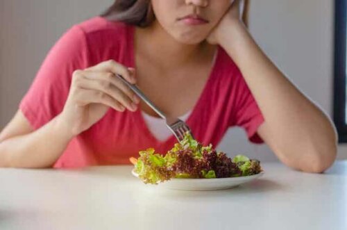 En kvinne som spiser en salat.