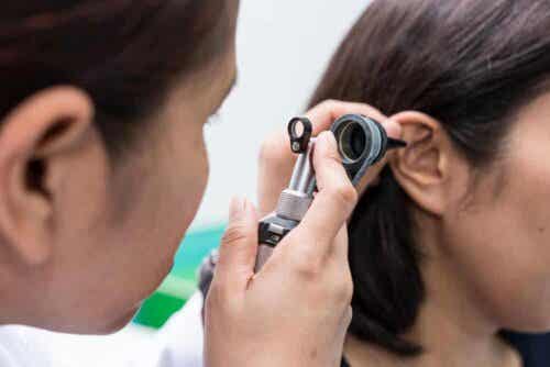 En lege som evaluerer pasientens øre.