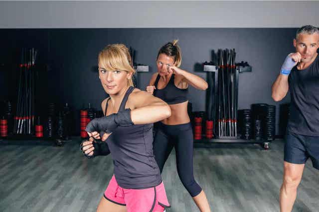 Menn og kvinner som deltar i en fitboksing-time