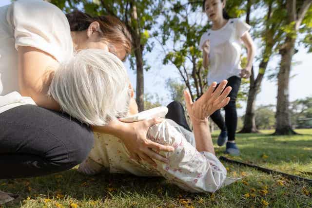 En besvimt kvinne i en park