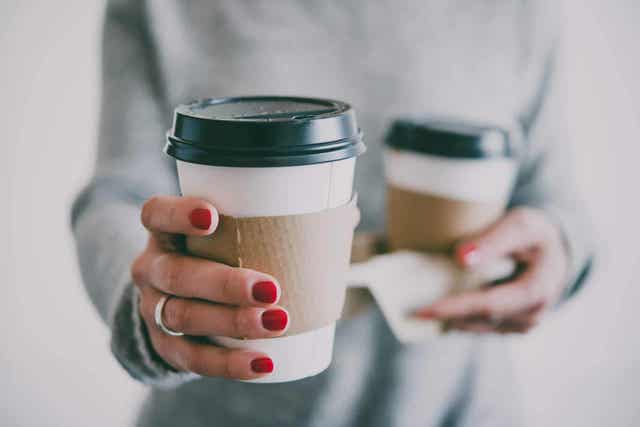 kvinne holder kaffe som kan motvirke tannbleking