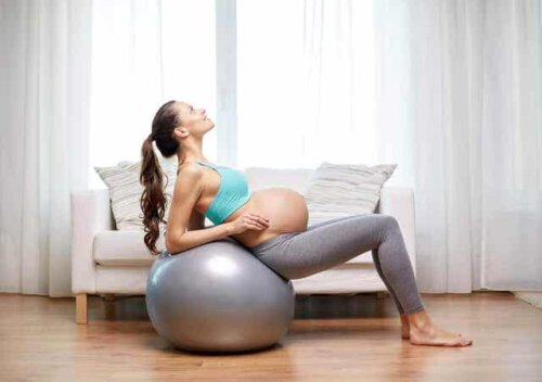 En gravid kvinne som bruker en ball av stor størrelse.