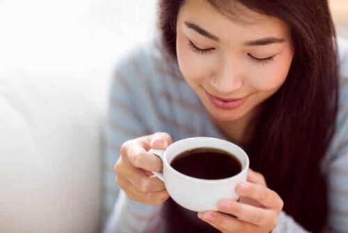 En kvinne som drikker en kopp kaffe.