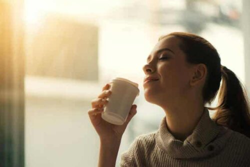 En kvinne som sitter på en kafé og drikker kaffe.