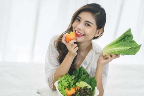 En kvinne som spiser ferske grønnsaker.