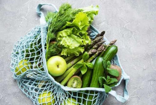 En pose med grønt frukt og grønnsaker.