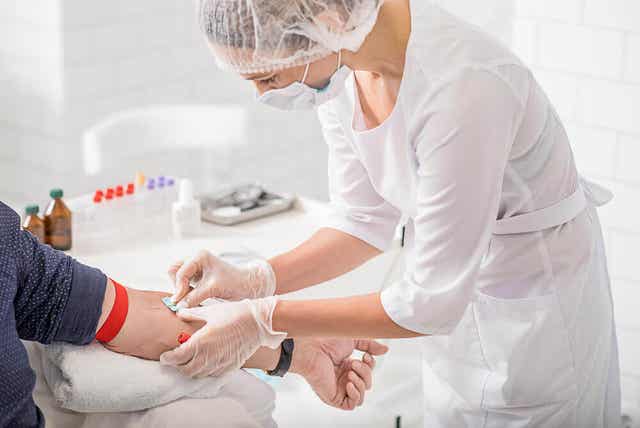 En sykepleier forbereder seg på å trekke blod fra en pasients arm.