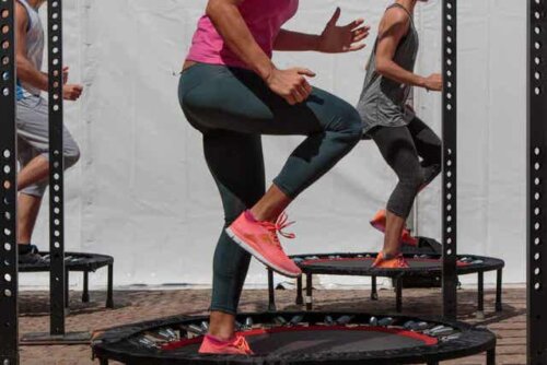 Flere voksne trener på individuelle trampoliner.