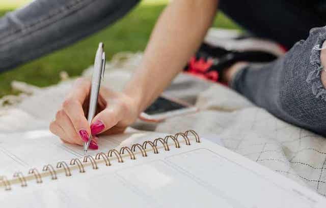En kvinne som skriver i journalen sin.
