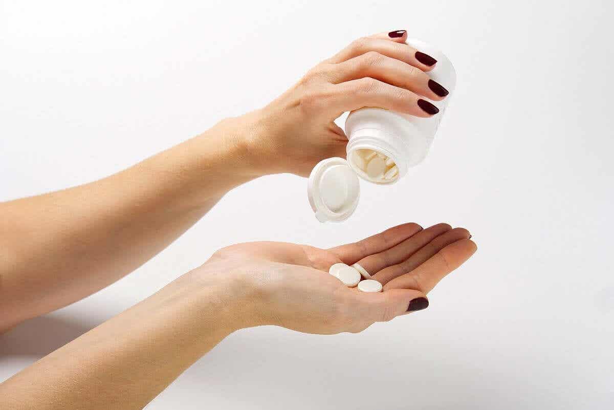 En kvinne som helter ut piller i hånden sin