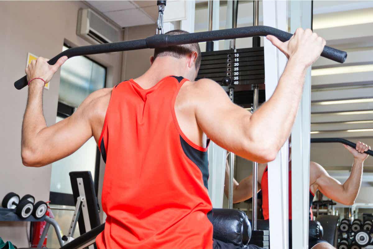 Typer stanggrep: en mann som bruker det tilbøyelige grepet på et treningsstudio.